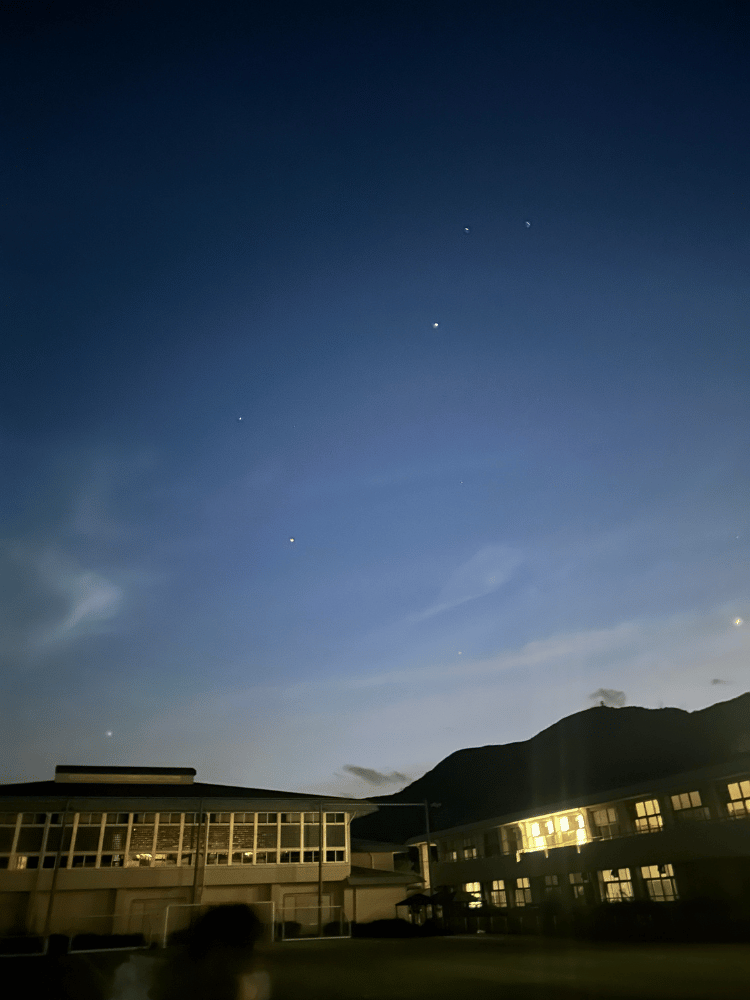 箱根キャンパスの夕暮れの空。薄いブルーの空に白い雲が広がり、数個の星が輝いている